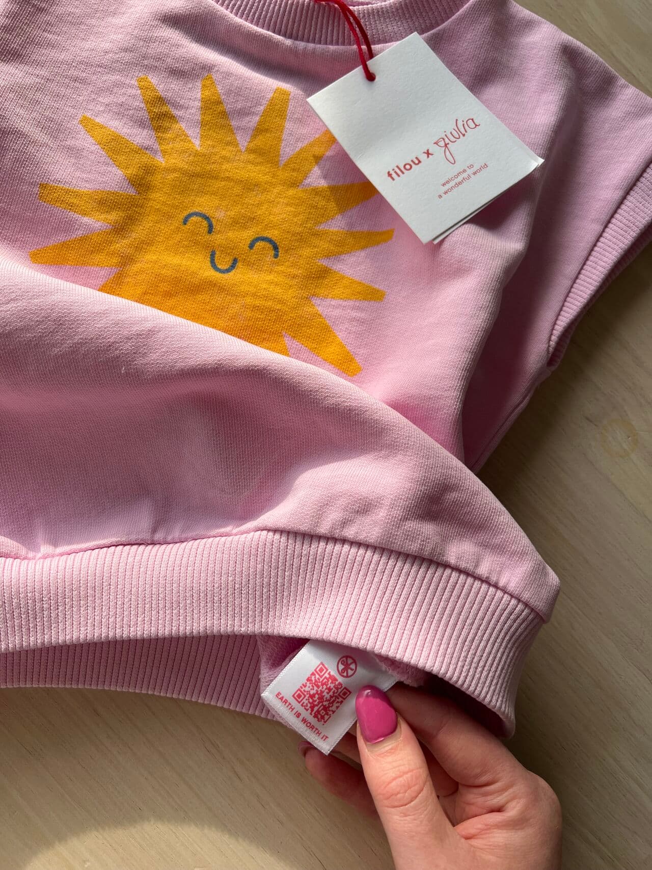 Filou x Giulia sweatshirt with its QR care label held open